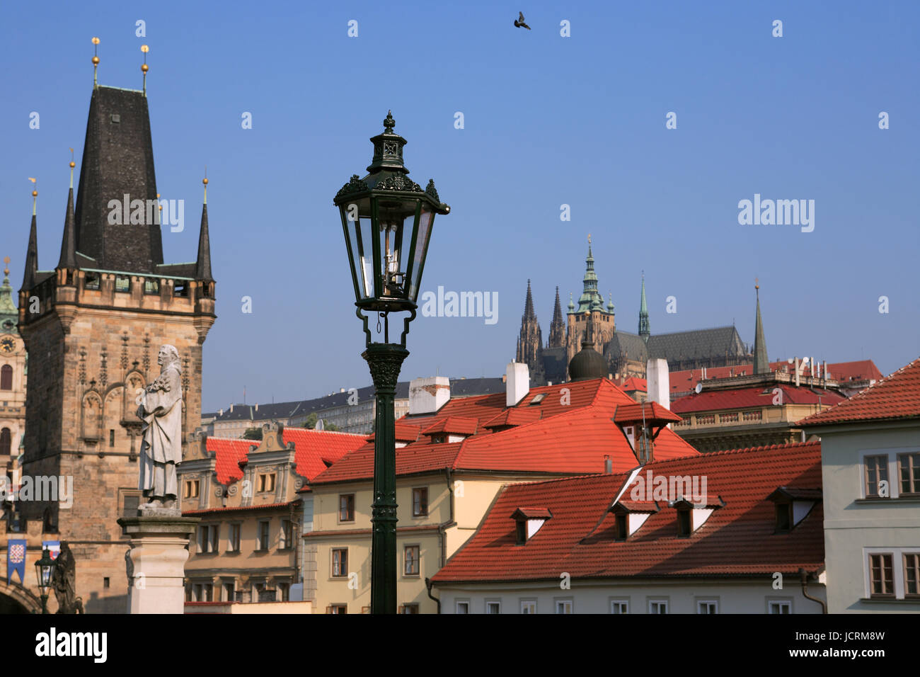 Vintage street lamp on background with gothic towers and tiled roofs in Prague Stock Photo