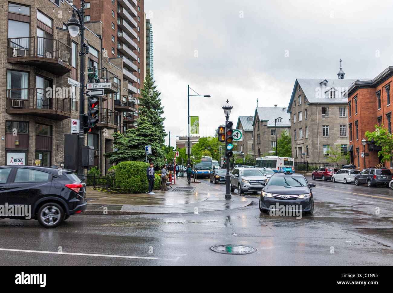 Montreal, Canada - May 26, 2017: Saint Laurent boulevard and Sherbrooke signs in Plateau area of city in Quebec region with cars on road and people wa Stock Photo