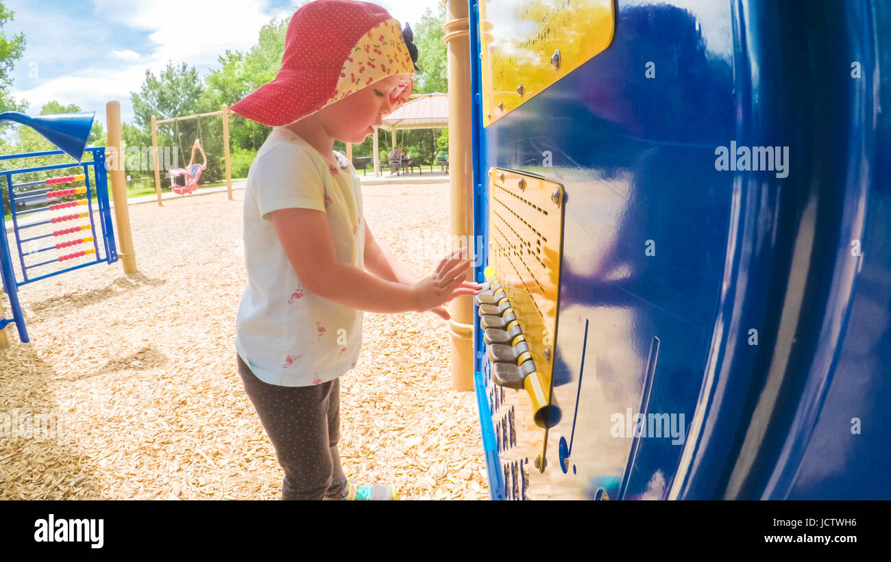 Little girl playing on the kids playground in the Summer Stock Photo ...
