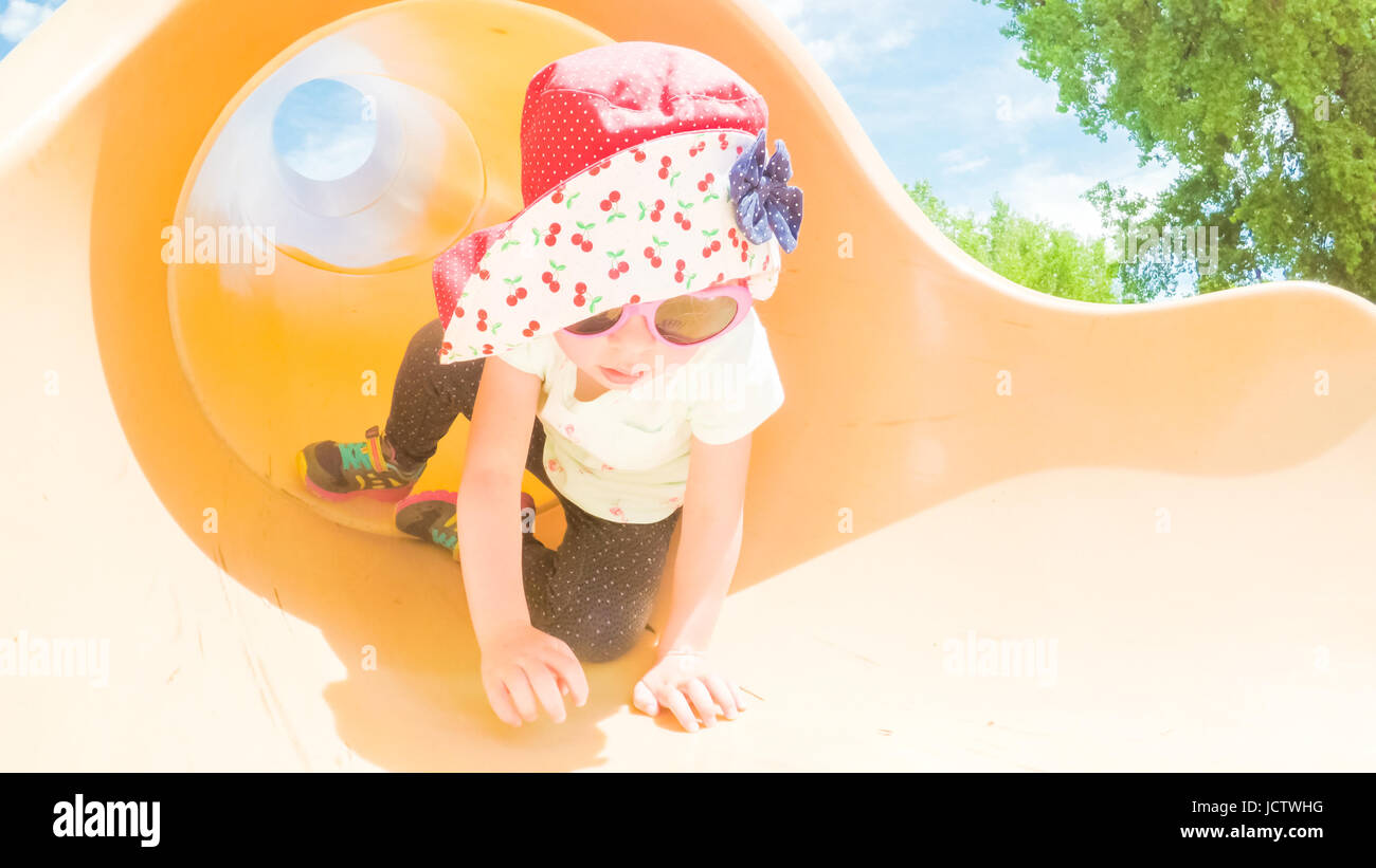 Little girl playing on the kids playground in the Summer Stock Photo ...