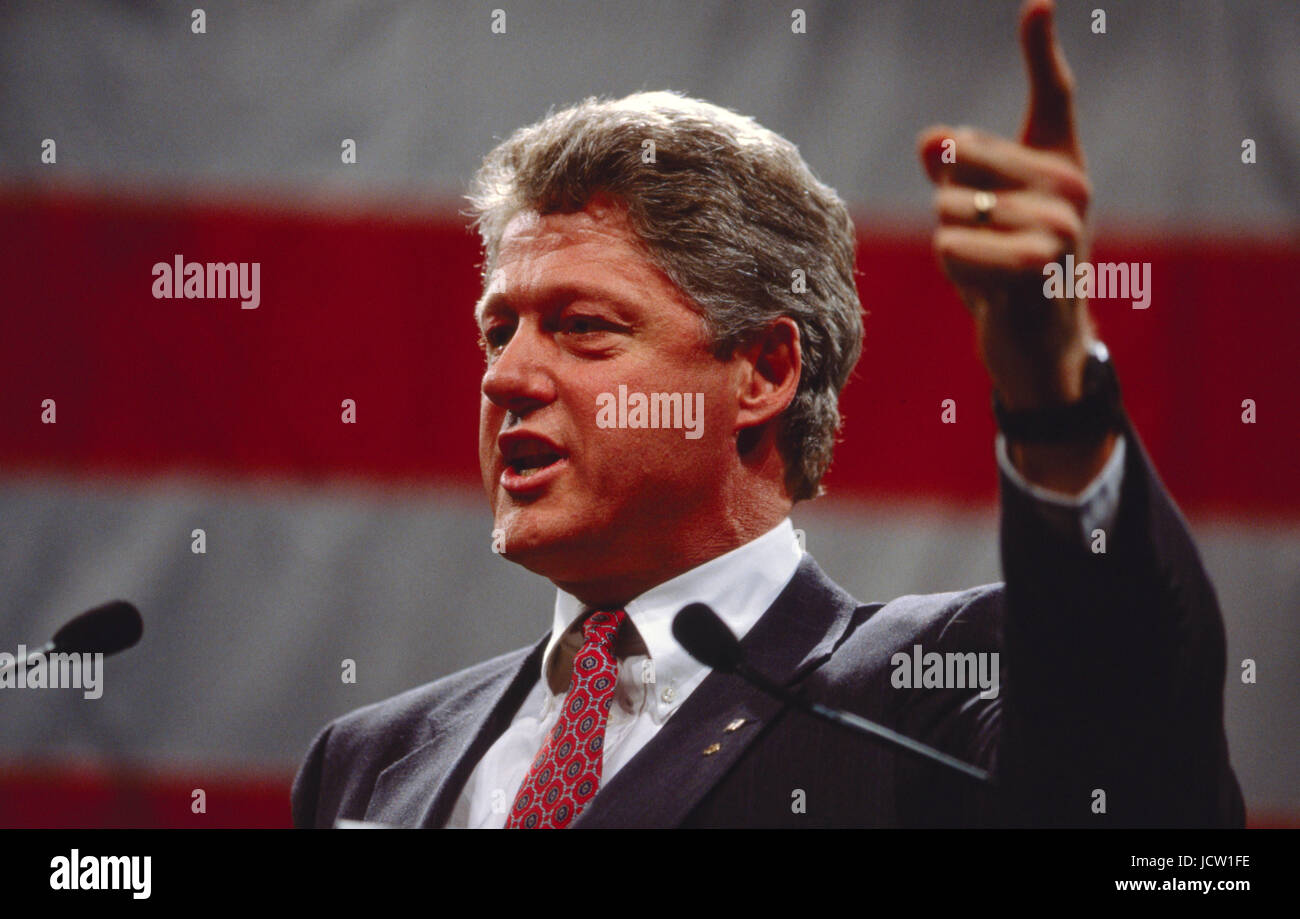 President Bill Clinton speaks in front of a large American flag. Stock Photo
