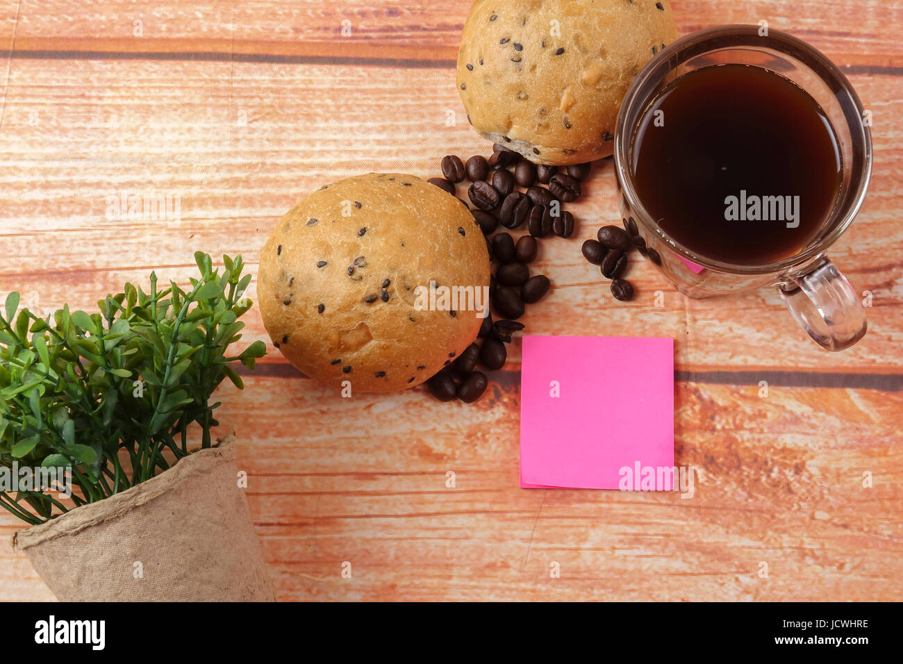 Morning breakfast concept with coffee,bun, post it notes on wooden ...