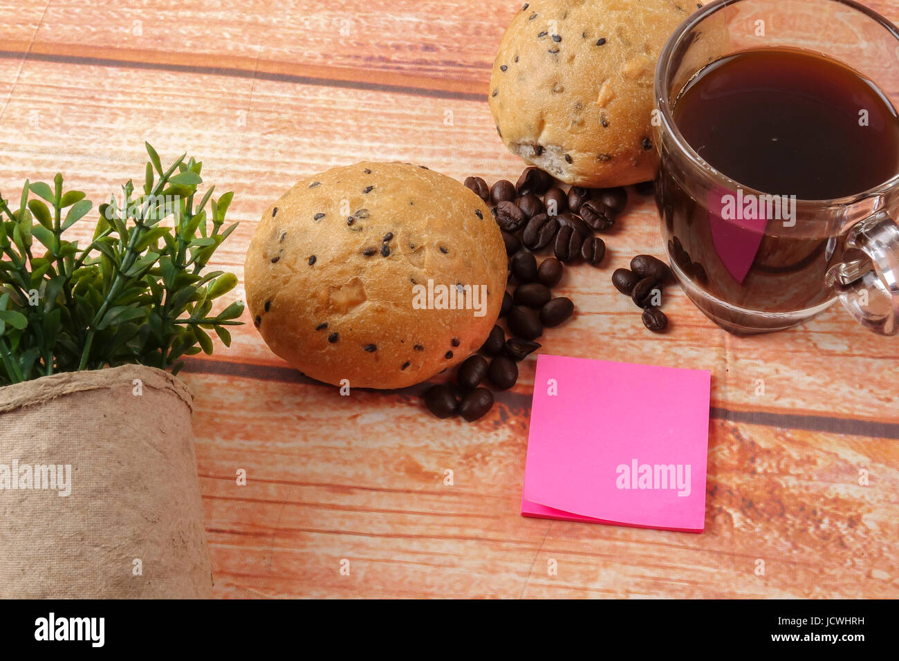 Morning breakfast concept with coffee,bun, post it notes on wooden ...
