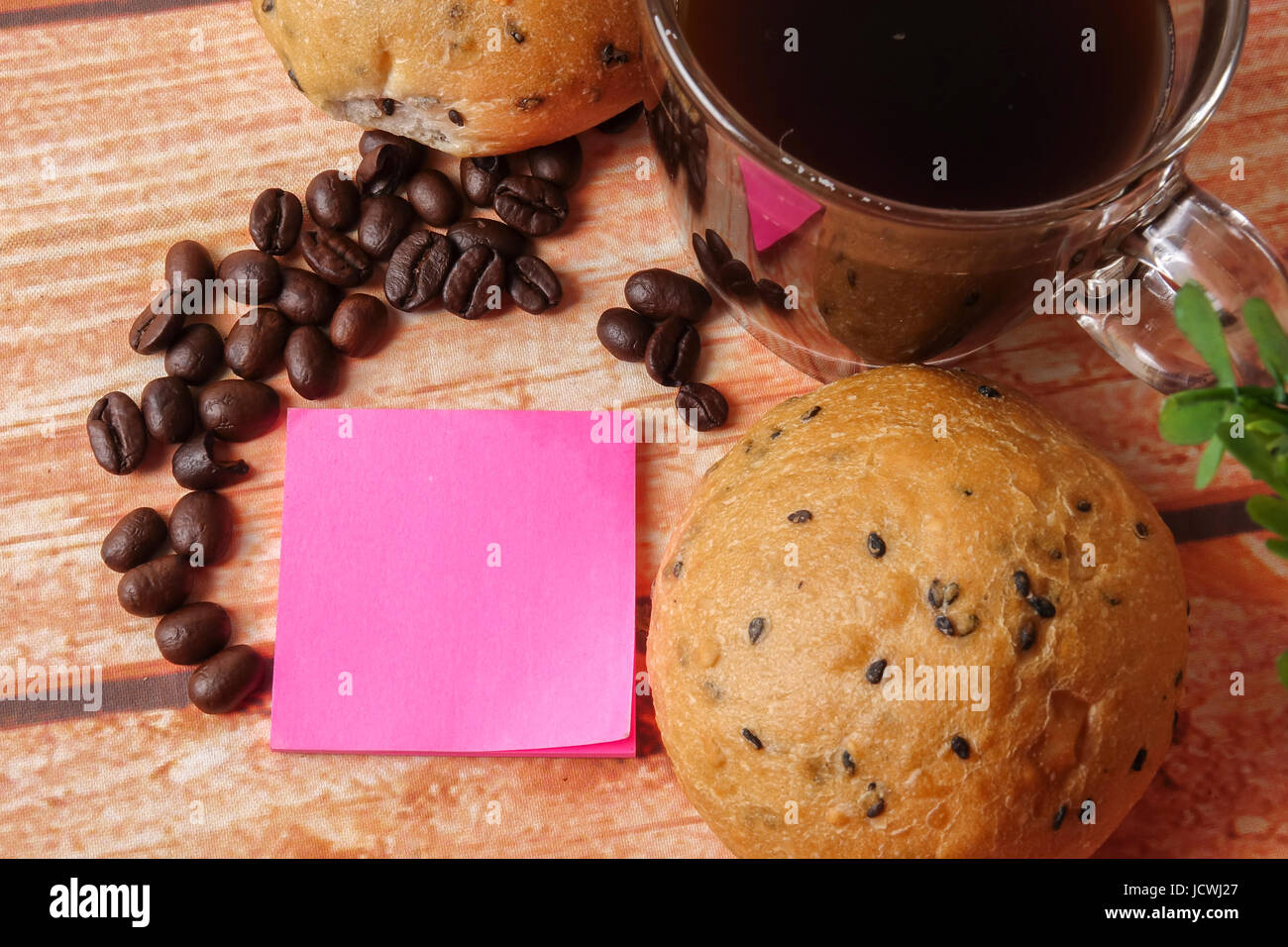Morning breakfast concept with coffee,bun, post it notes on wooden ...
