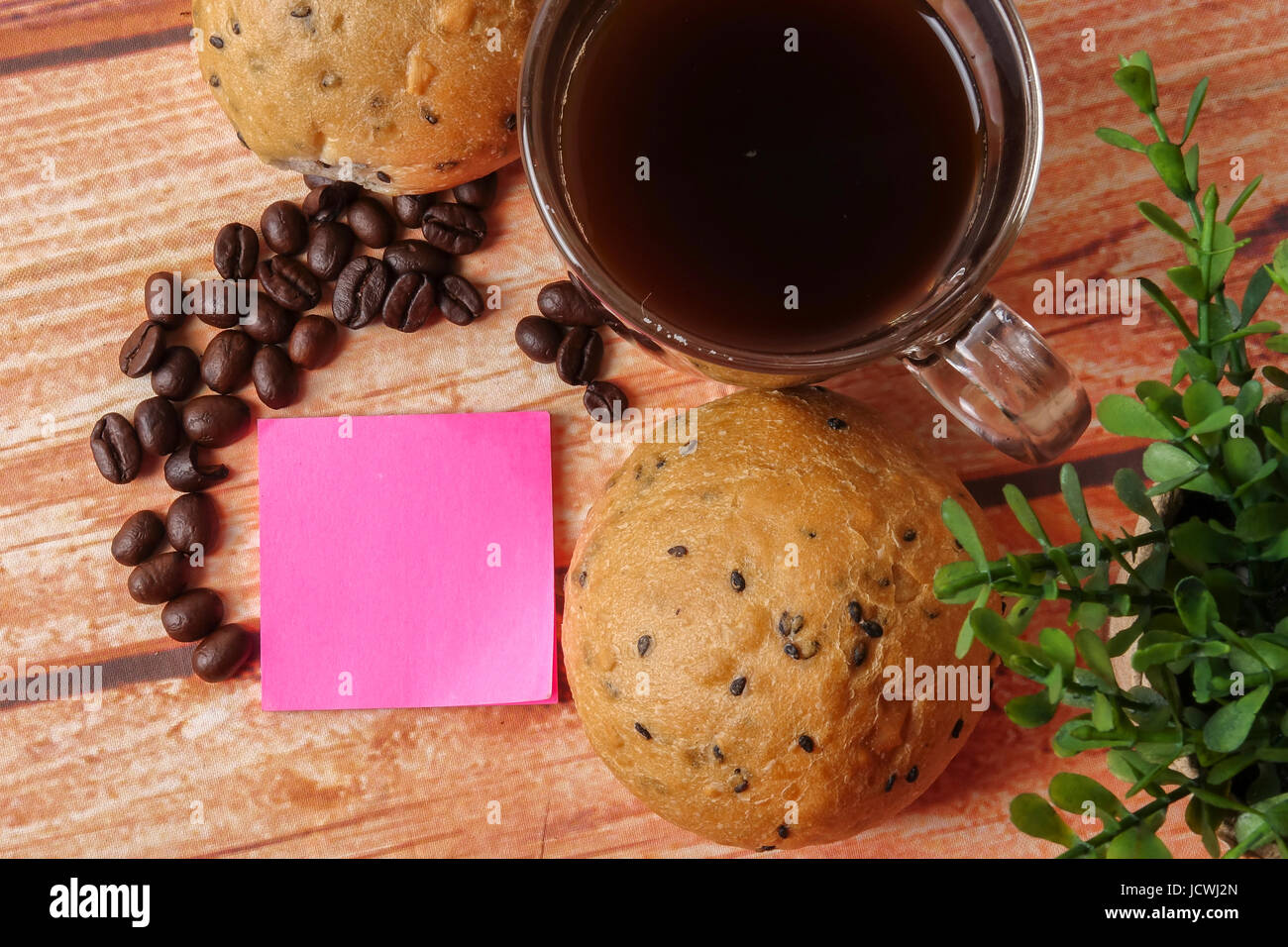 Morning breakfast concept with coffee,bun, post it notes on wooden ...
