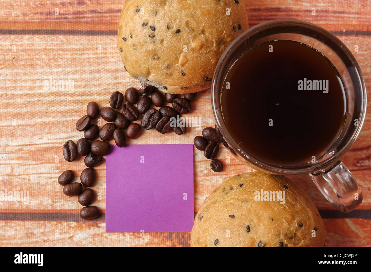 Morning breakfast concept with coffee,bun, post it notes on wooden ...