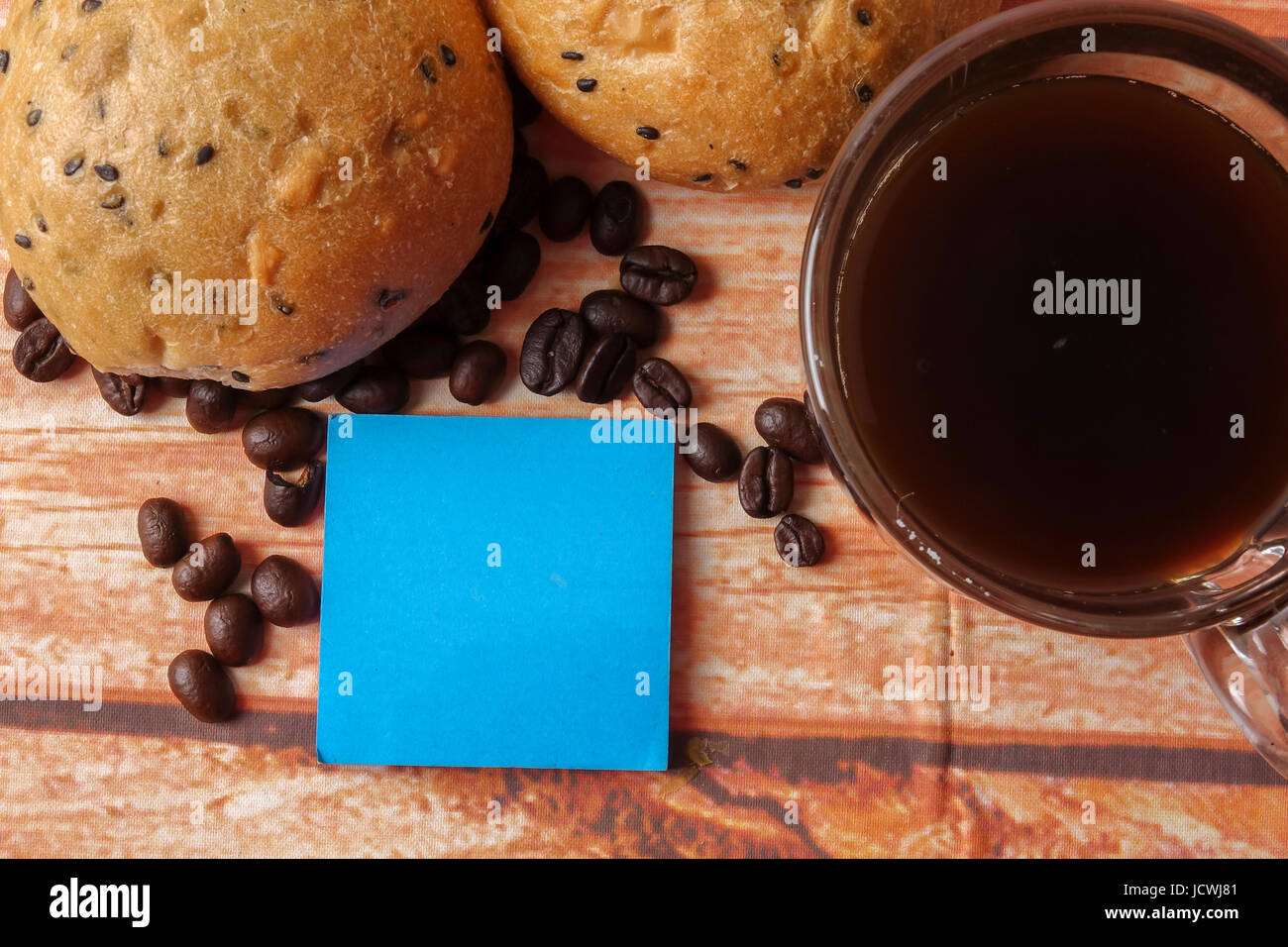 Morning breakfast concept with coffee,bun, post it notes on wooden ...