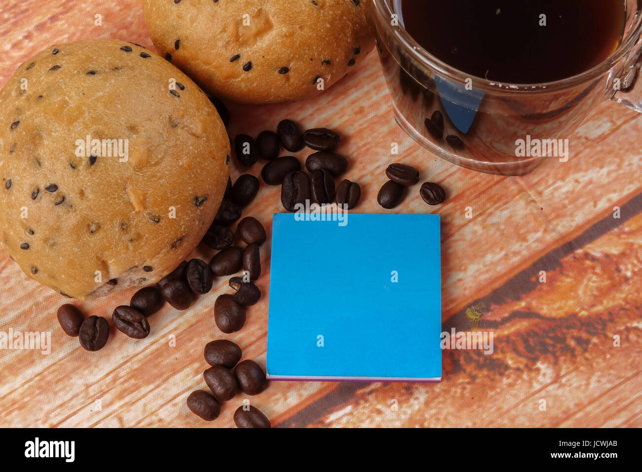 Morning breakfast concept with coffee,bun, post it notes on wooden ...