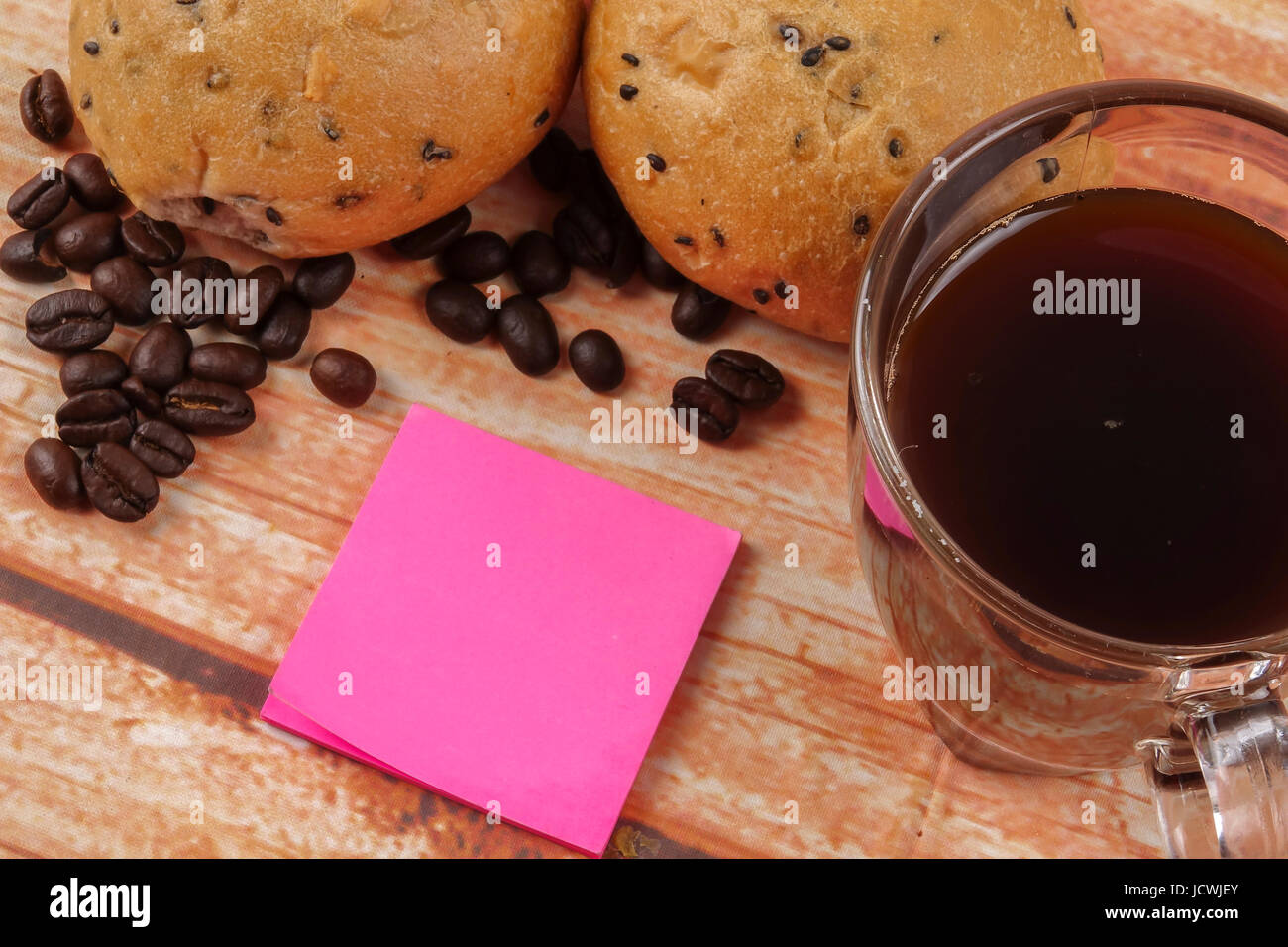Morning breakfast concept with coffee,bun, post it notes on wooden ...