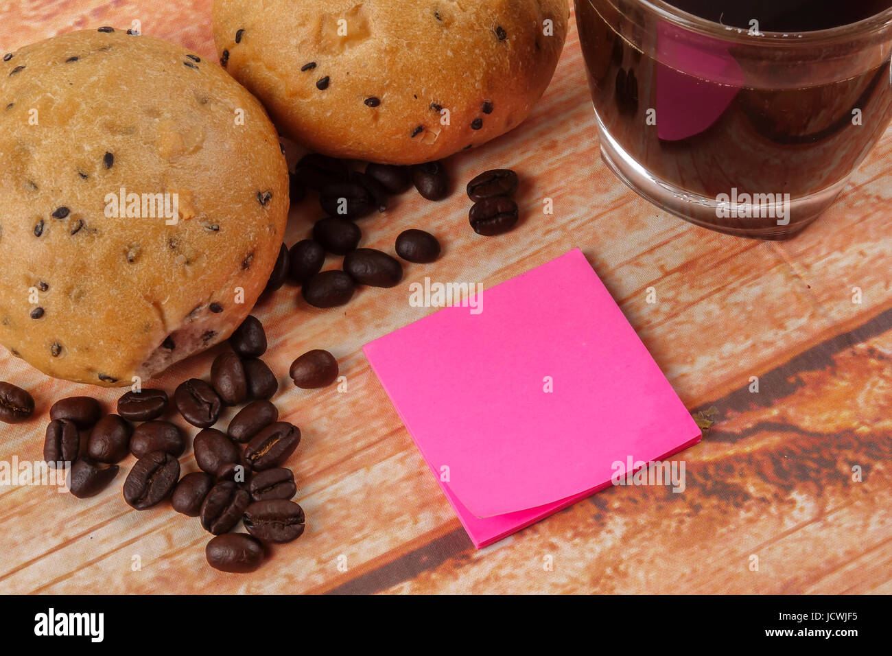 Morning breakfast concept with coffee,bun, post it notes on wooden ...