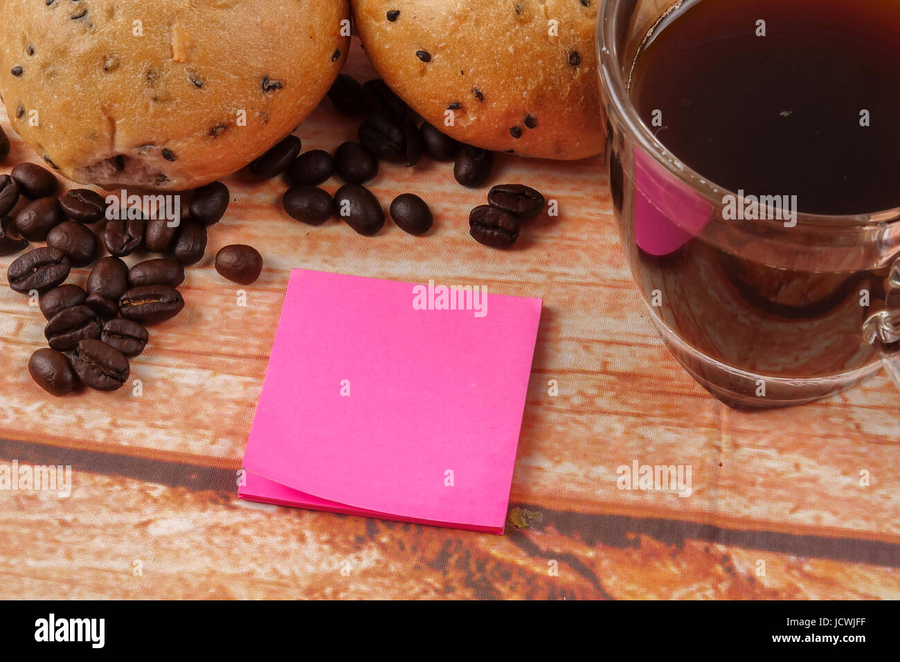 Morning breakfast concept with coffee,bun, post it notes on wooden ...