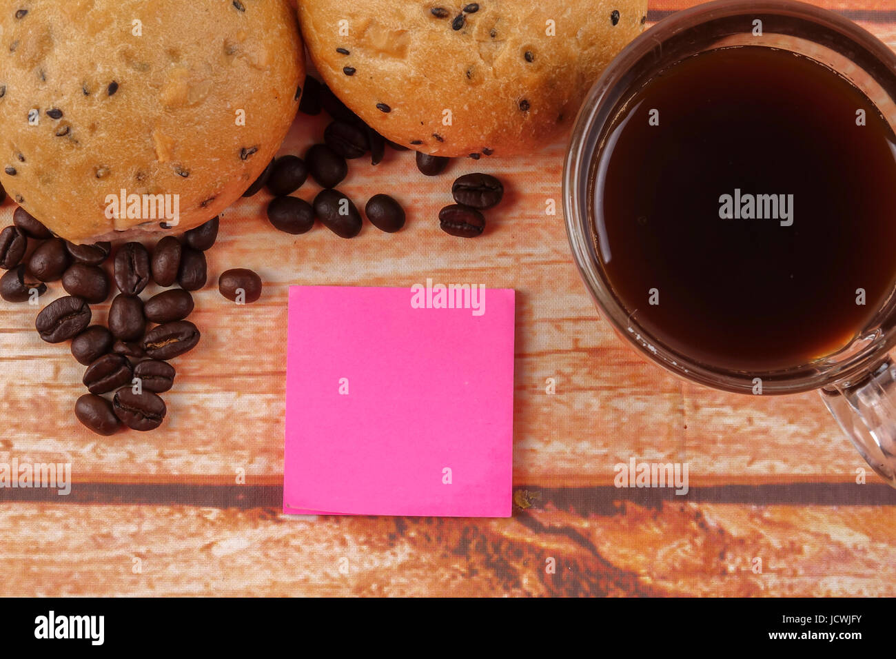Morning breakfast concept with coffee,bun, post it notes on wooden ...