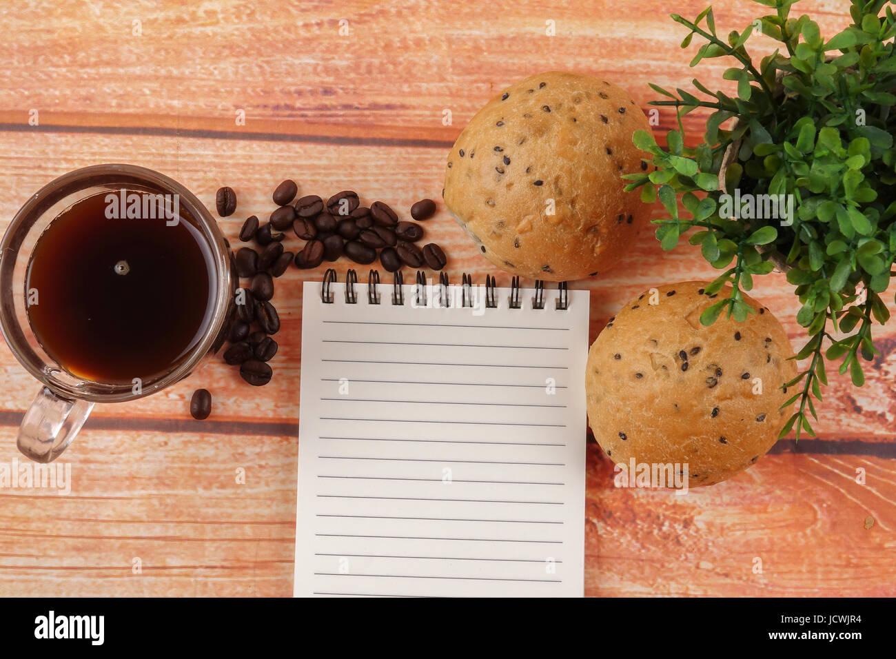 Morning breakfast concept with coffee,bun, post it notes on wooden ...