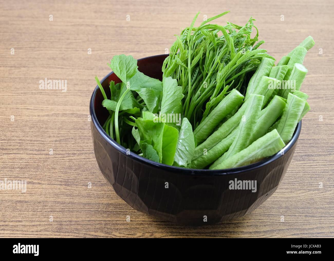 Vegetable, A Bowl of Fresh Green Cowpeas, Leucaena Leucocephala and Gotu Kola Leaves on Wooden Table with Copy Space for Text Decorated. Stock Photo