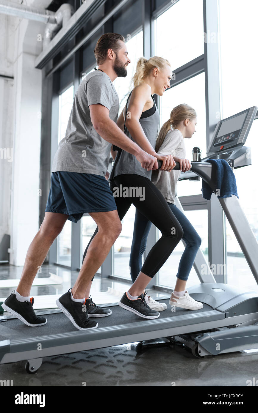 Happy family workout on treadmill side view Stock Photo Alamy