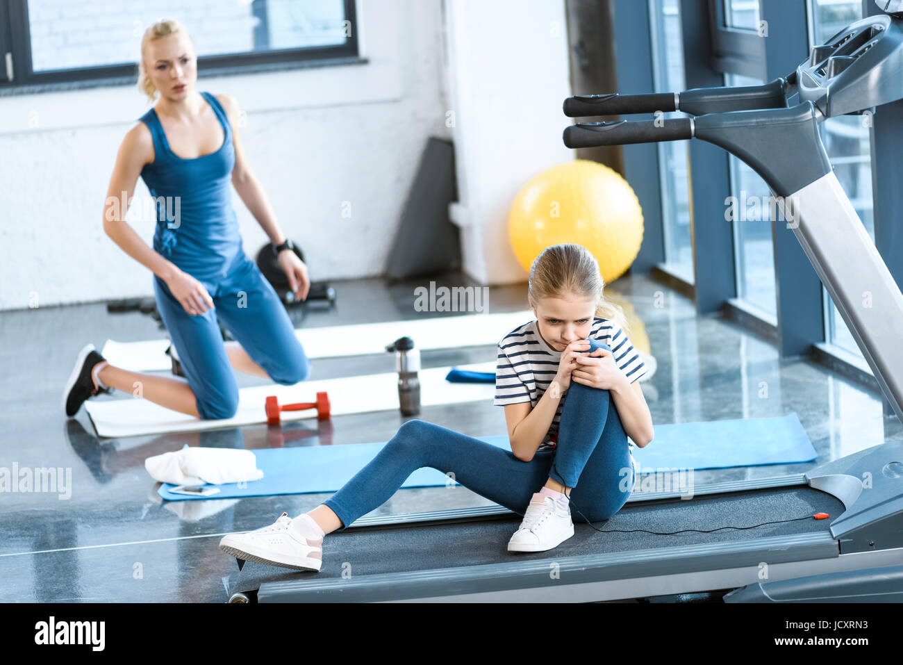 girl injured knee sitting on treadmill Stock Photo Alamy