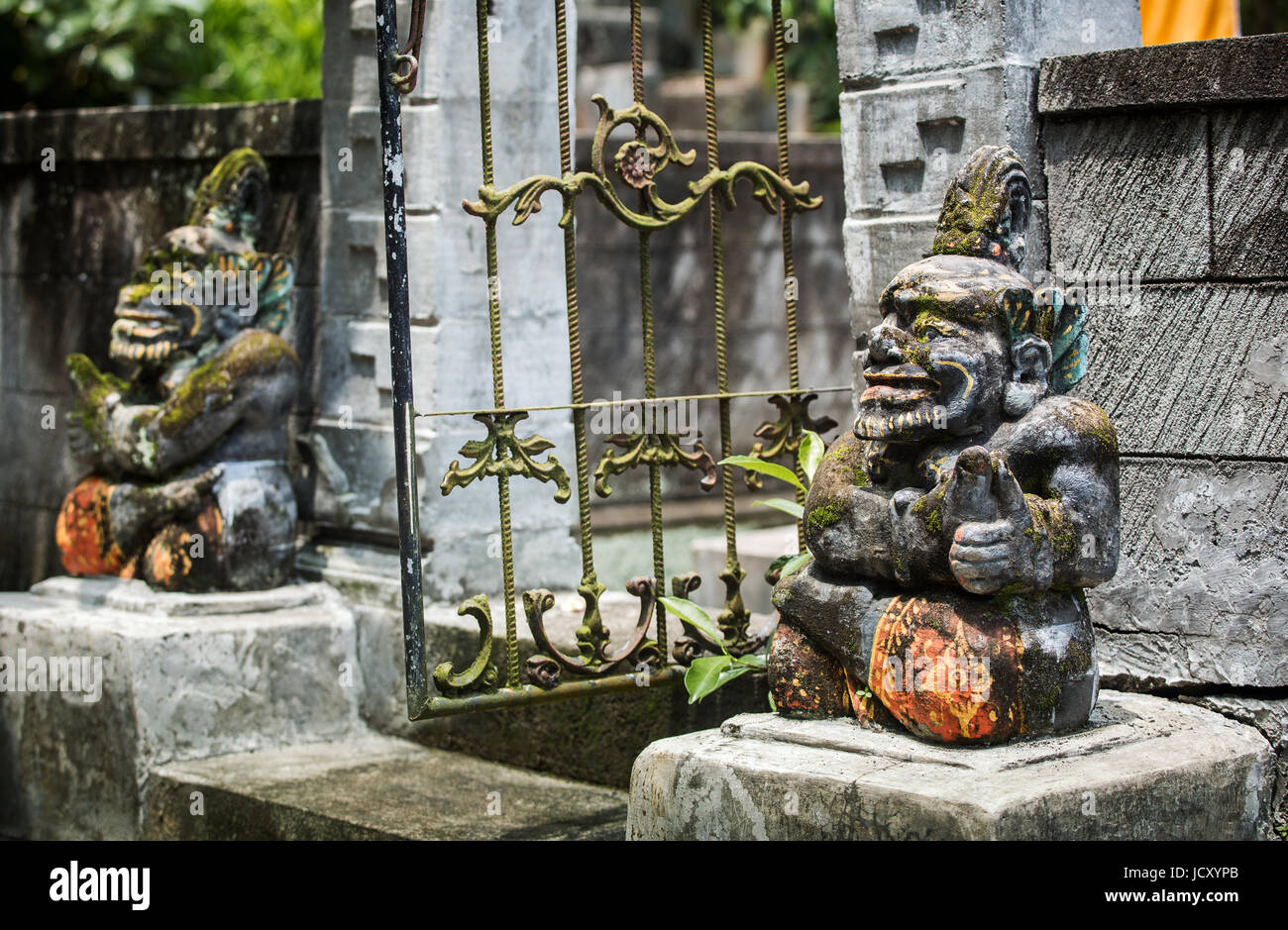 Balinese statues, unique effigies carved from stone guarding the entrance to a Hindu Temple. Balinese statues in the Hindu religion are common place Stock Photo