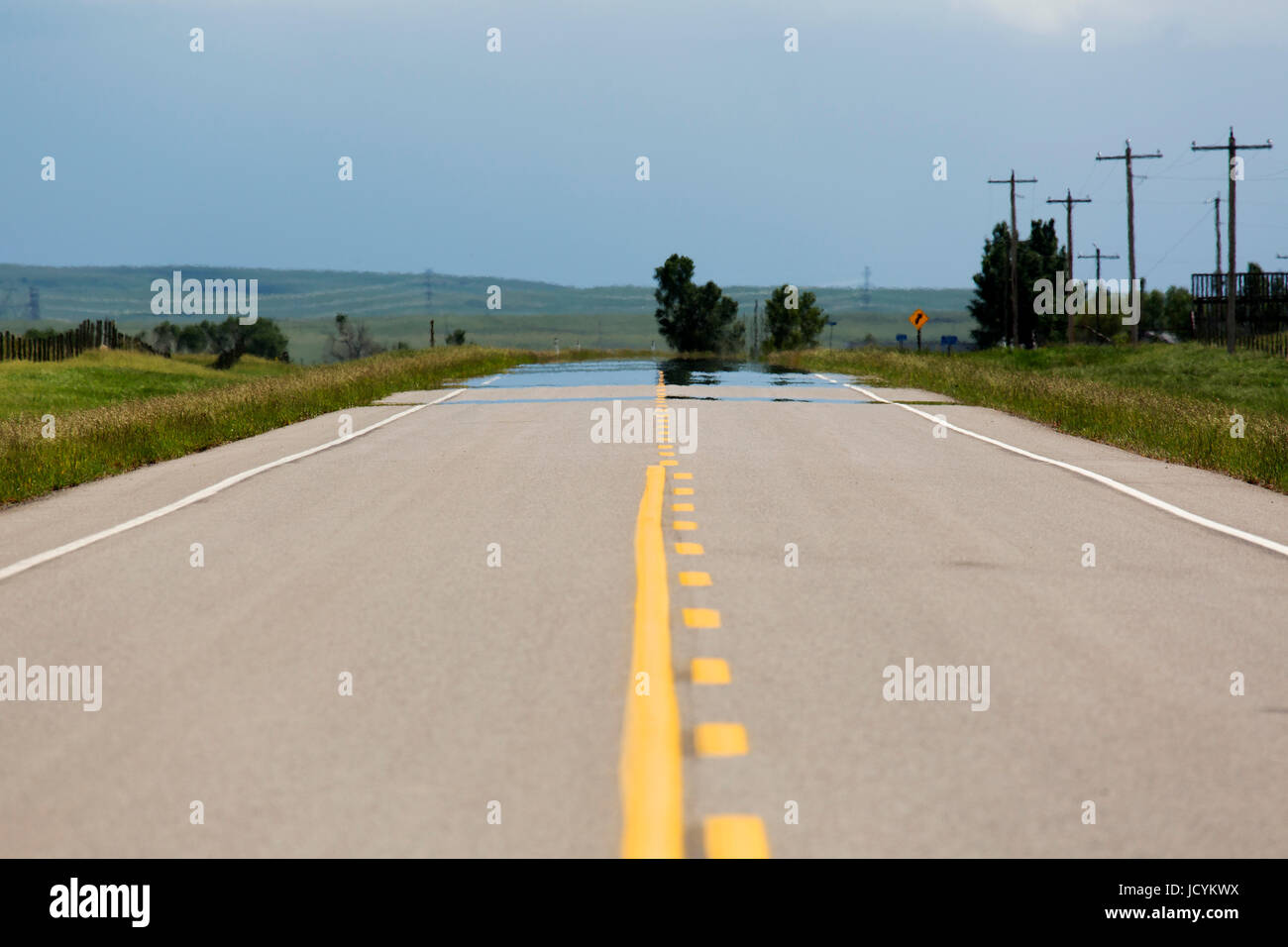 Empty road in Alberta, Canada. The tarmac on the highway has yellow lane markings. Stock Photo