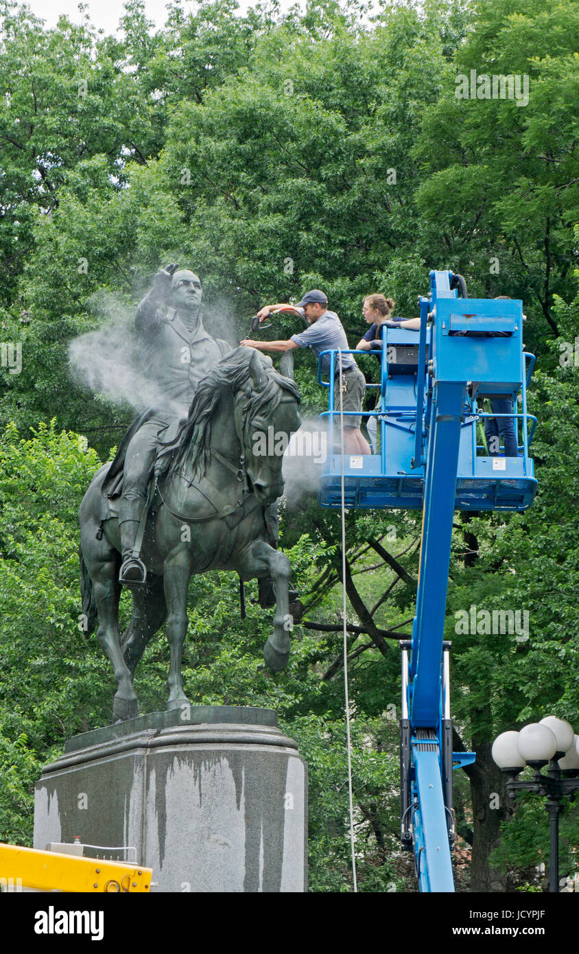 The statue of George Washington in Union Square Park getting its annual cleaning by a Parks Dept worker and an intern. Stock Photo