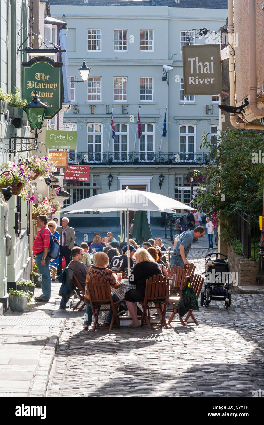 People sat outside the Blarney Stone resstaurant in Church Lane, Windsor, Berkshire, England, United Kingdom on a sunny day Stock Photo