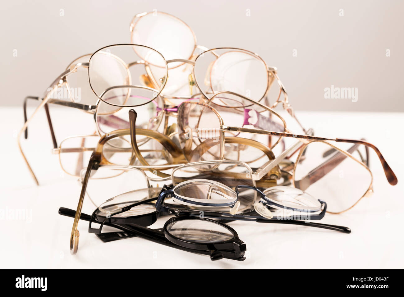 Cluster, pile of old eye glasses on with table, ready to recycle Stock