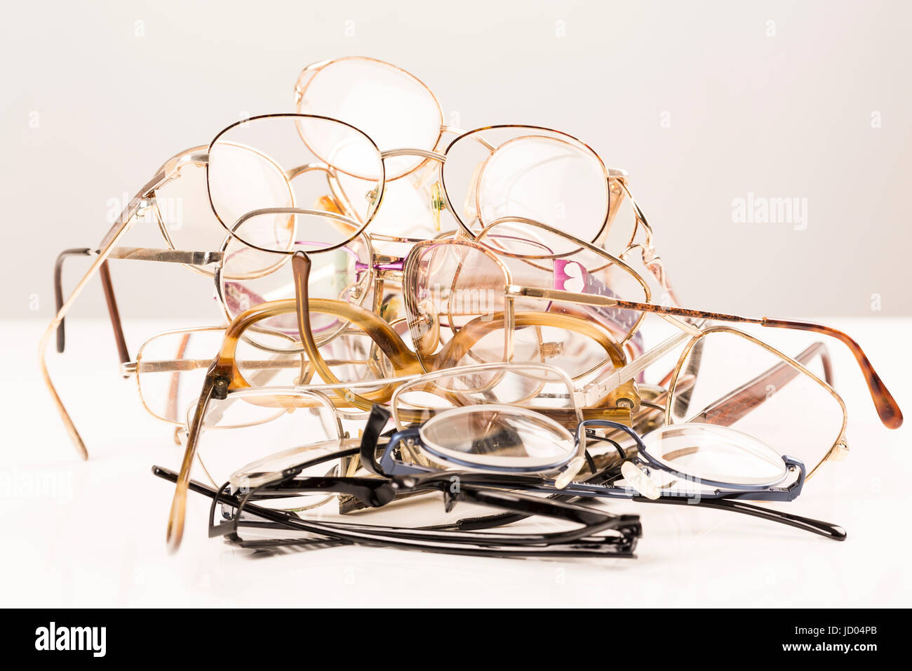Cluster, pile of old eye glasses on with table, ready to recycle Stock