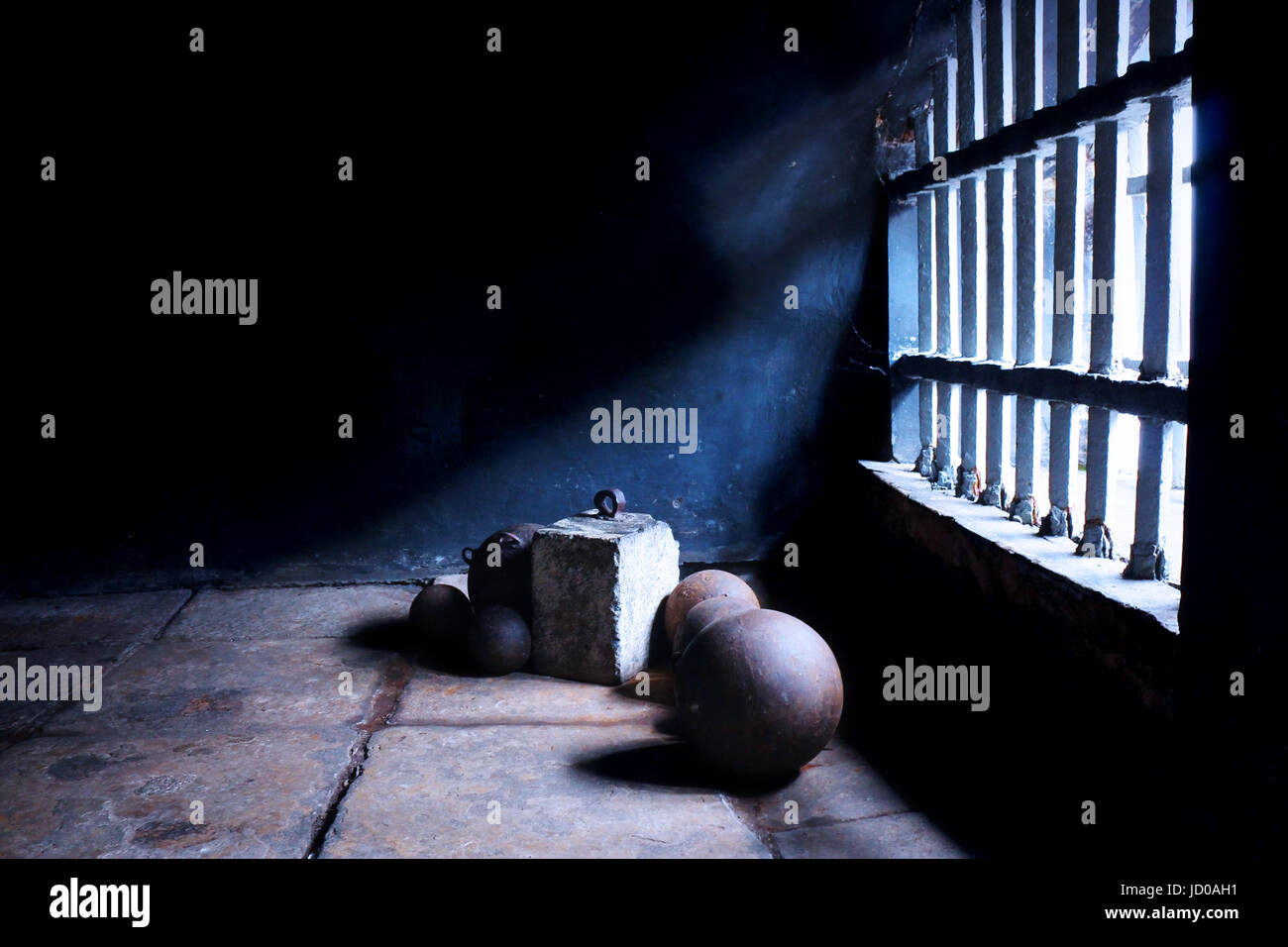 Iron balls and a concrete block shackles in an old colonial styled prison under a historical building in Old Town, Jakarta, Indonesia. Stock Photo