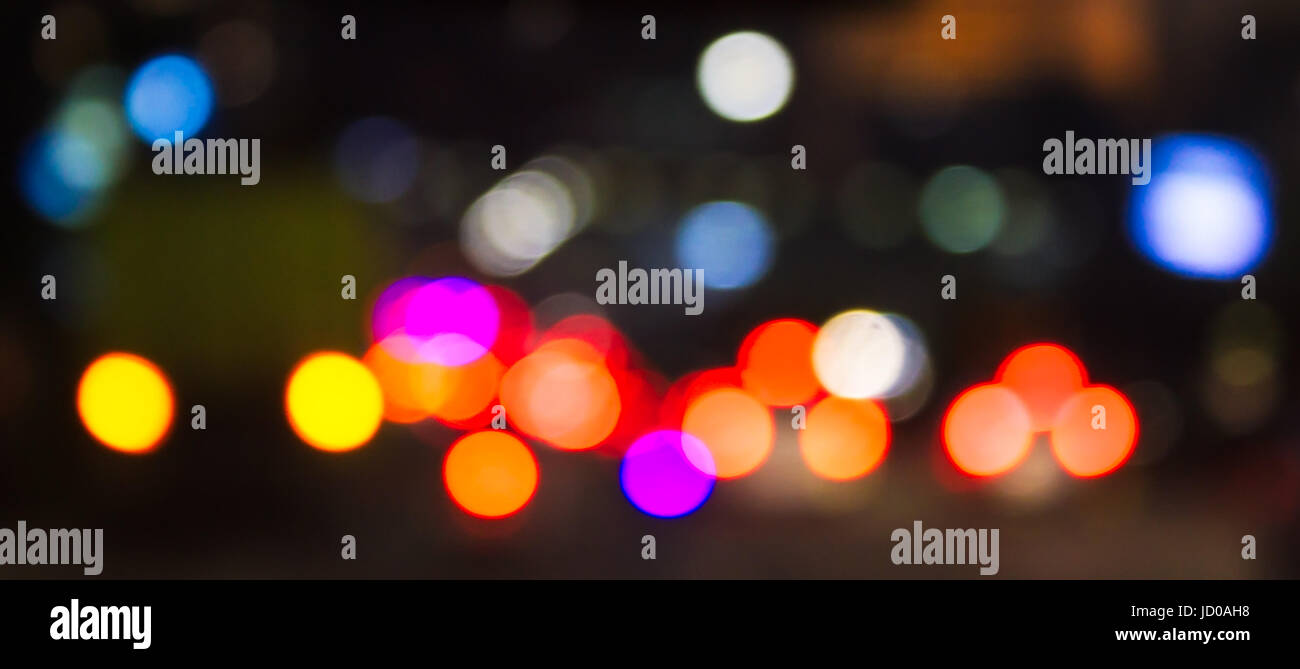 Defocus car tail lights in the night traffic. The shot was taken by altering the lens focus ring. Stock Photo