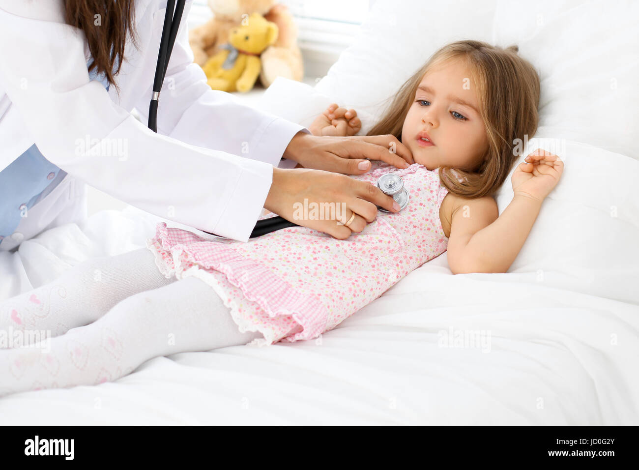 Doctor examining a little girl by stethoscope Stock Photo - Alamy