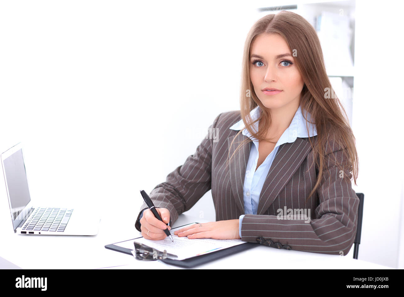Young business woman sitting at the desk on office background Stock ...
