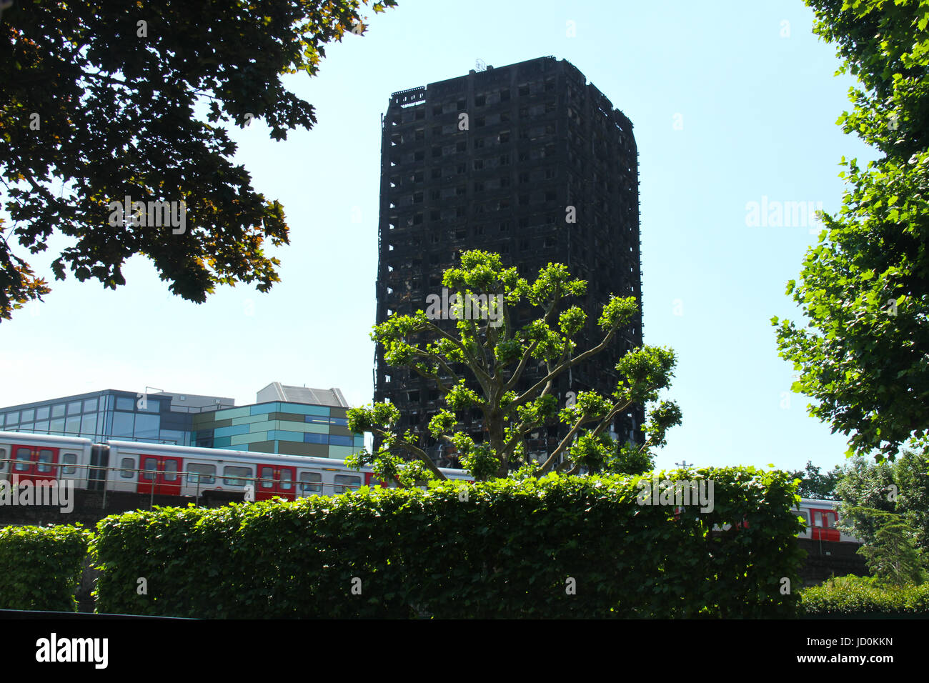 London, UK. 16th June, 2017. A tube train from Latimer Statin speeds on the tracks below the charred remains of the 24-storey block Grenfell tower block. At least 30 people have bene confirmed dead with about 70 missing and feared dead. Credit: David Mbiyu/Alamy Live News  Stock Photo