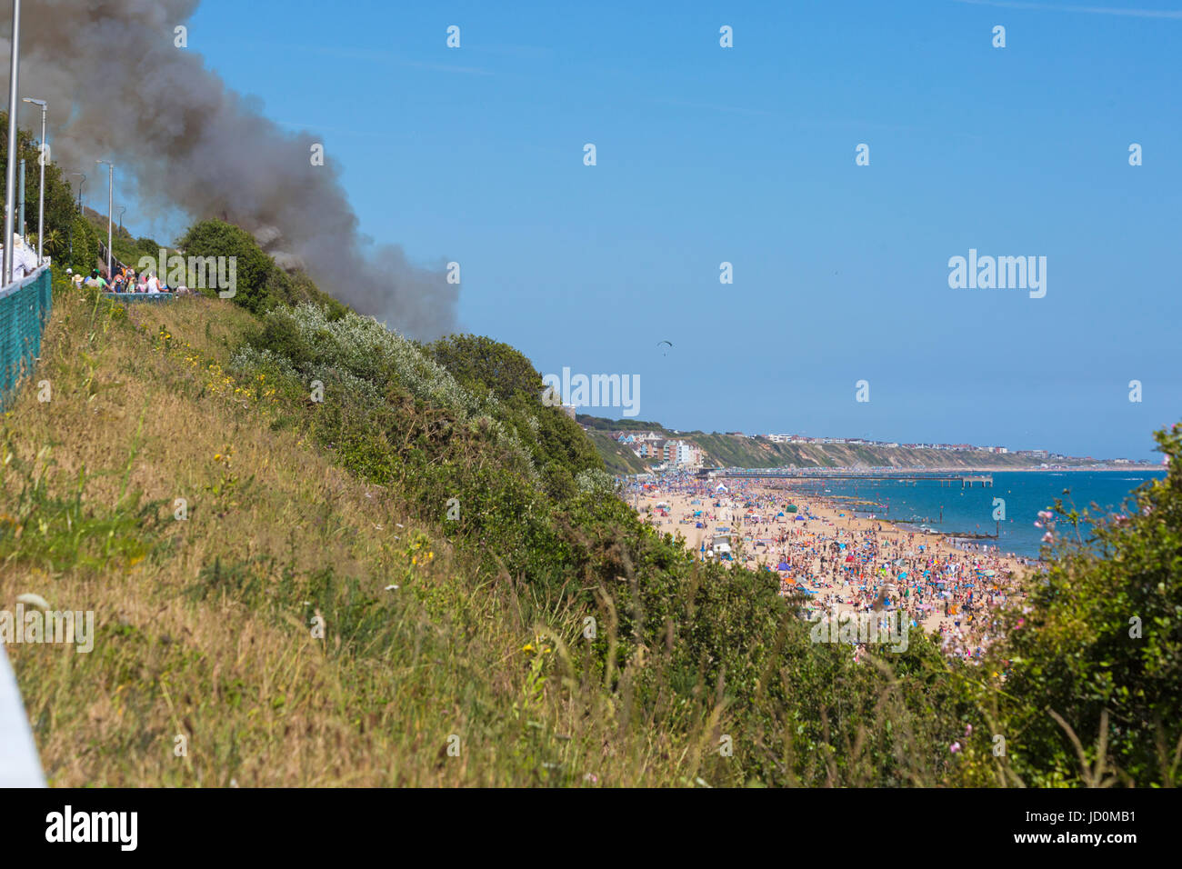 Bournemouth, Dorset, UK. 17th June, 2017. Fire at Bournemouth beach on the hottest day of the year with crowded beaches on a day with hot sunny weather. It was believed a smoke bomb was thrown into the bushes behind the beach huts at Eastcliff which set fire to gorse bushes and went up in smoke as beach goers looked on. Credit: Carolyn Jenkins/Alamy Live News Stock Photo