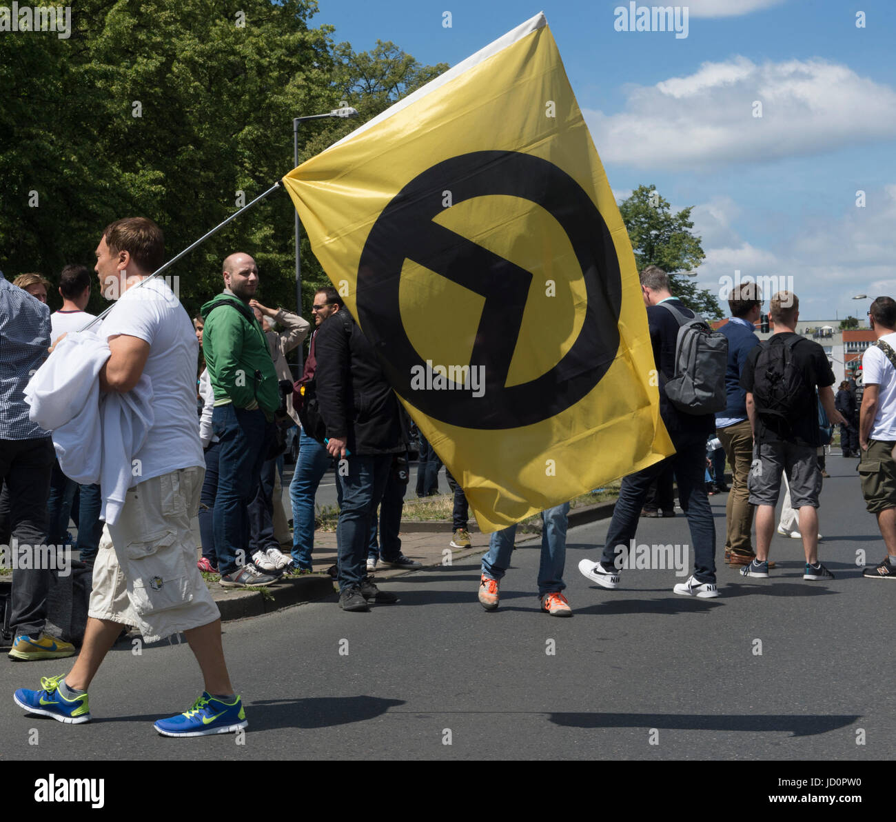 Berlin, Germany. 17th June, 2017. A supporter of the right-wing 'Identitaere Bewegung' (lit. identitarian movement) with a flag on Brunnenstrasse in Berlin, Germany, 17 June 2017. Various groups protested against a demonstration by the right-wing group. Photo: Paul Zinken/dpa/Alamy Live News Stock Photo