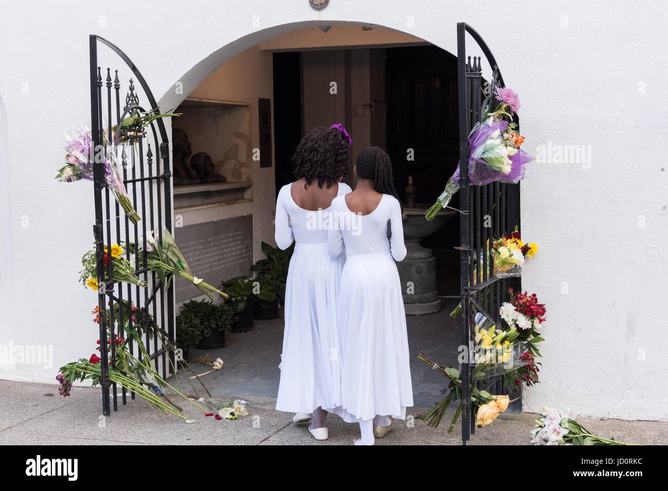 Charleston, South Carolina, USA. 17th June, 2017. Young members of the praise dance group of the Mother Emanuel African Methodist Episcopal Church view floral tributes left at the church on the 2nd anniversary of the mass shooting June 17, 2017 in Charleston, South Carolina. Nine members of the historic African-American church were gunned down by a white supremacist during bible study on June 17, 2015. Credit: Planetpix/Alamy Live News Stock Photo