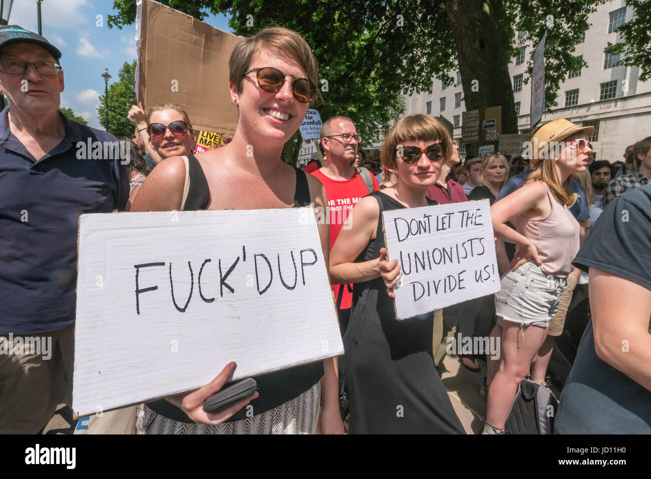 June 17, 2017 - London, UK - London, UK. 17th June, 2017. Women hold up posters against the DUP at the protest at Downing St calling on Theresa May to resign. Mostly made up of vocal supporters of Jeremy Corbyn, buoyed up by the election results which showed him to be eminently electable, there were speeches by Labour MPs Marsha De Cordova who gained Battersea from the Conservatives, Rupa Huq who greatly increased her tiny majority and Shadow Education Secretary Angela Rayner. There were others who spoke about the DUP, as a party intrinsically linked with Protestant terrorist groups and domina Stock Photo