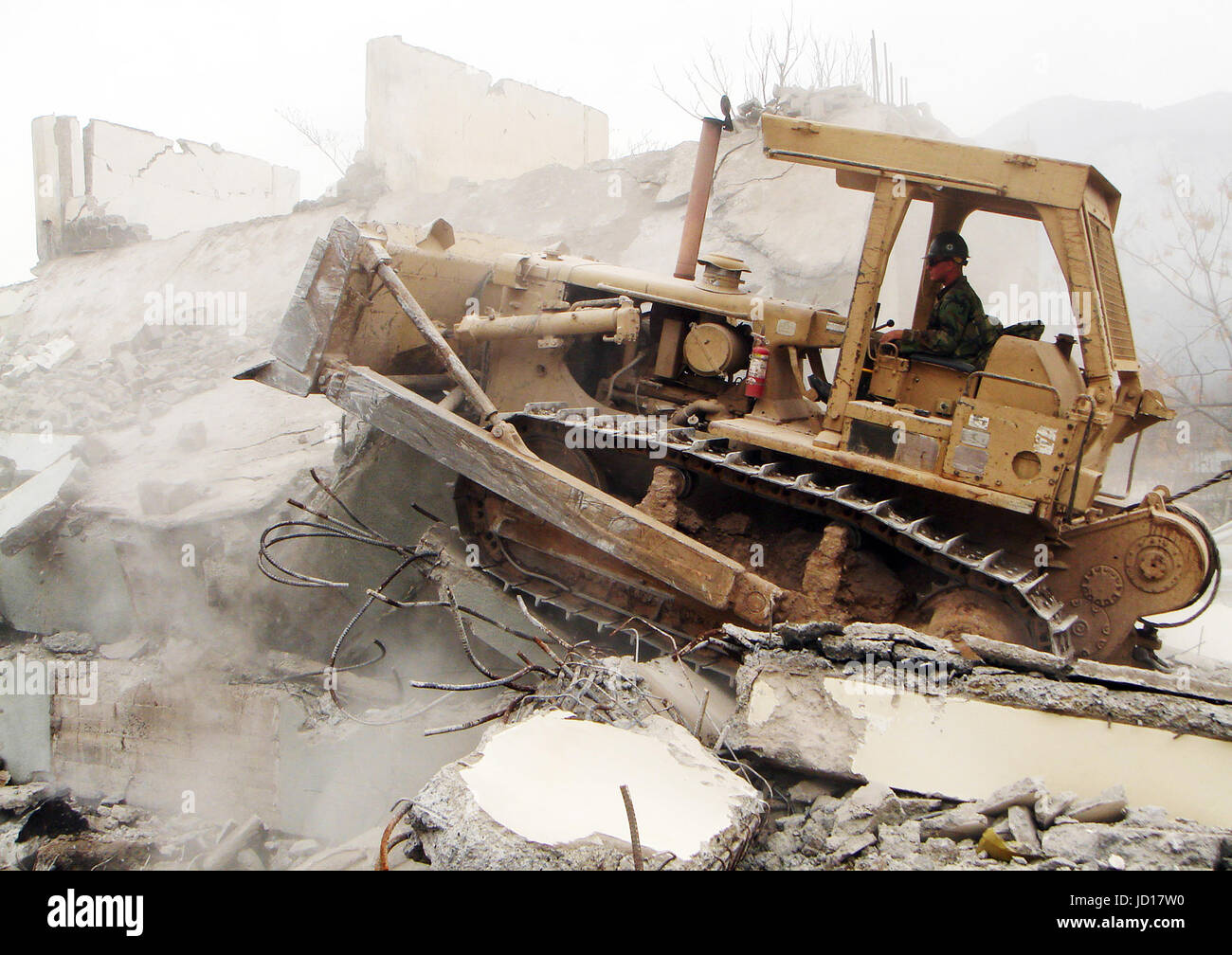 A U.S. Navy Seabee operates a bulldozer to demolish an unsafe building in Muzaffarabad, Pakistan. The Department of Defense is supporting the US State Department and provided disaster relief supplies and services following the massive earthquake that struck Pakistan and parts of India and Afghanistan.  DoD photo by Petty Officer 2nd Class James Godown, U.S. Navy Stock Photo