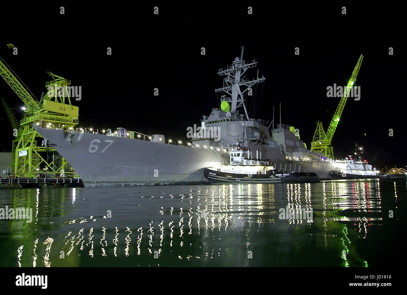 Tugs gently push the USS Cole to its mooring at the Ingalls Shipyard in Pascagoula, Miss., on Dec. 24, 2000.  The Arleigh Burke class destroyer was the target of a terrorist attack in the port of Aden, Yemen, on Oct. 12, 2000, during a scheduled refueling.  The attack killed 17 crew members and injured 39 others.  The Cole was transported from Aden to Pascagoula by the Norwegian heavy transport ship M/V Blue Marlin.    DoD photo by Chief Petty Officer Johnny R. Wilson, U.S. Navy Stock Photo