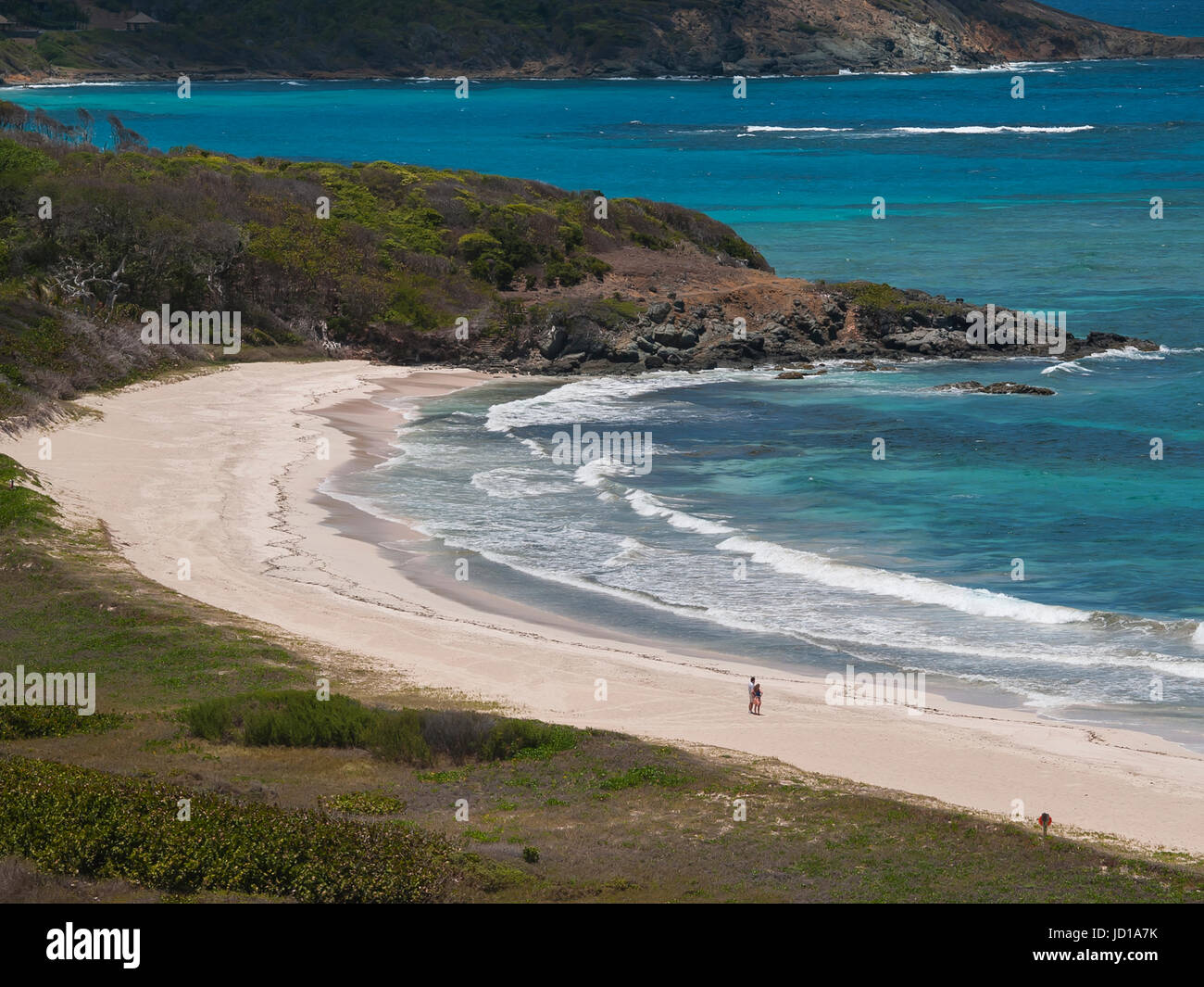 The empty white beach at Pasture Bay, Mustique Island, Grendadine Islands with its azure blue sea. romantic honeymoon couple alone on the beach. Stock Photo