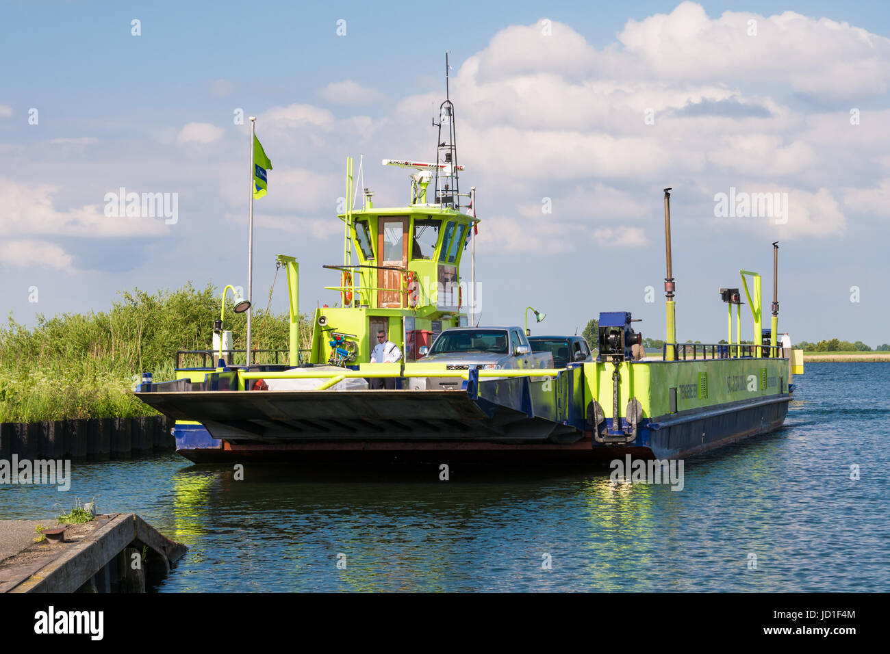 Ferry boat with cars and passengers arriving on Tiengemeten island in Haringvliet estuary, South Holland, Netherlands Stock Photo