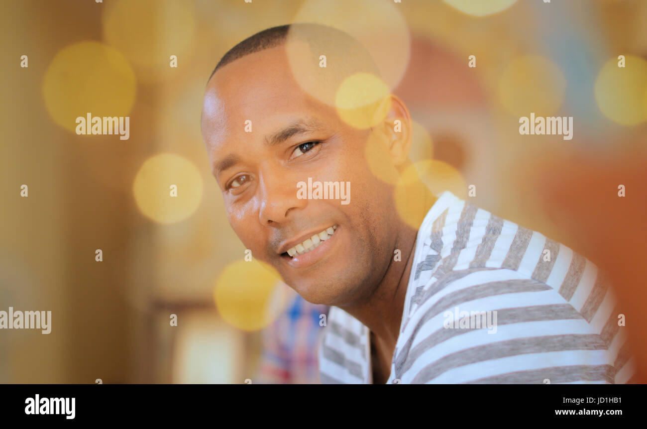 Portrait of homosexual adult man. Happy hispanic gay smiling at camera, sitting on sofa at home. Stock Photo