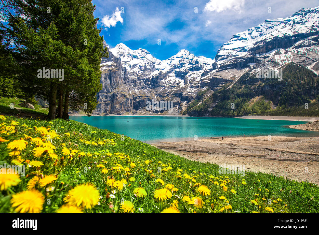 Amazing tourquise Oeschinnensee with waterfalls, wooden chalet and Swiss Alps, Berner Oberland, Switzerland. Stock Photo