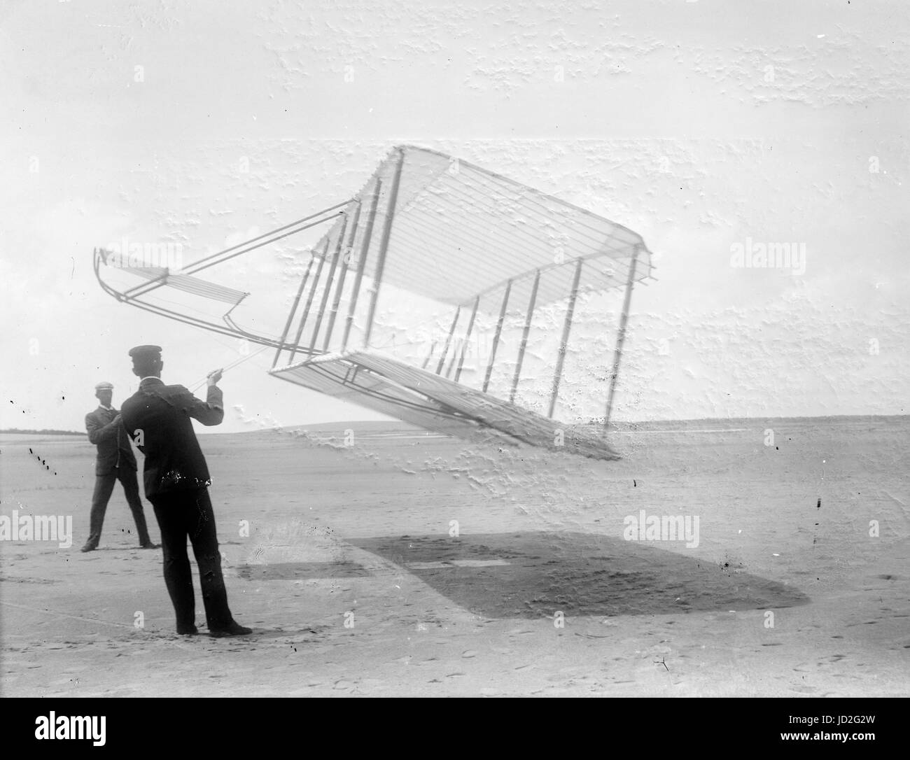 Side view of glider flying as a kite near the ground, Wilbur at left