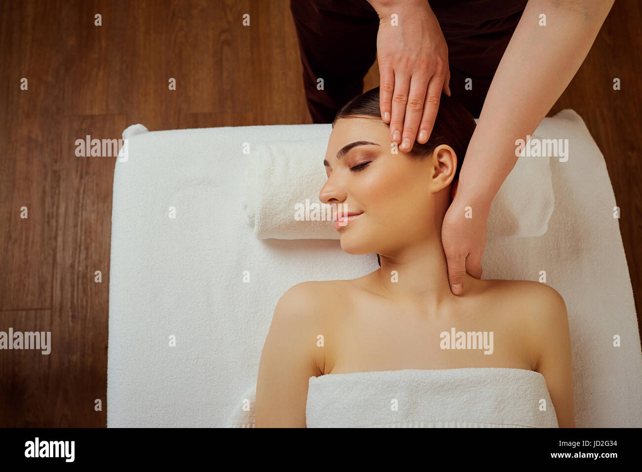 Massage the head of  neck to a young woman in massage room Stock Photo