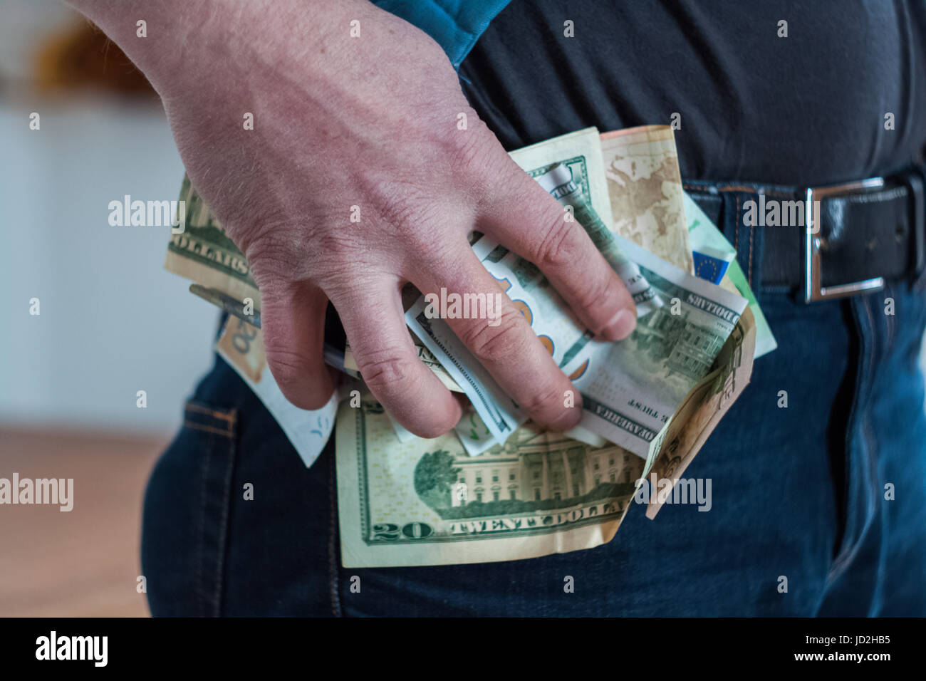 Paper money man holding tightly pinched in his hand, trying to slip into your pocket Stock Photo