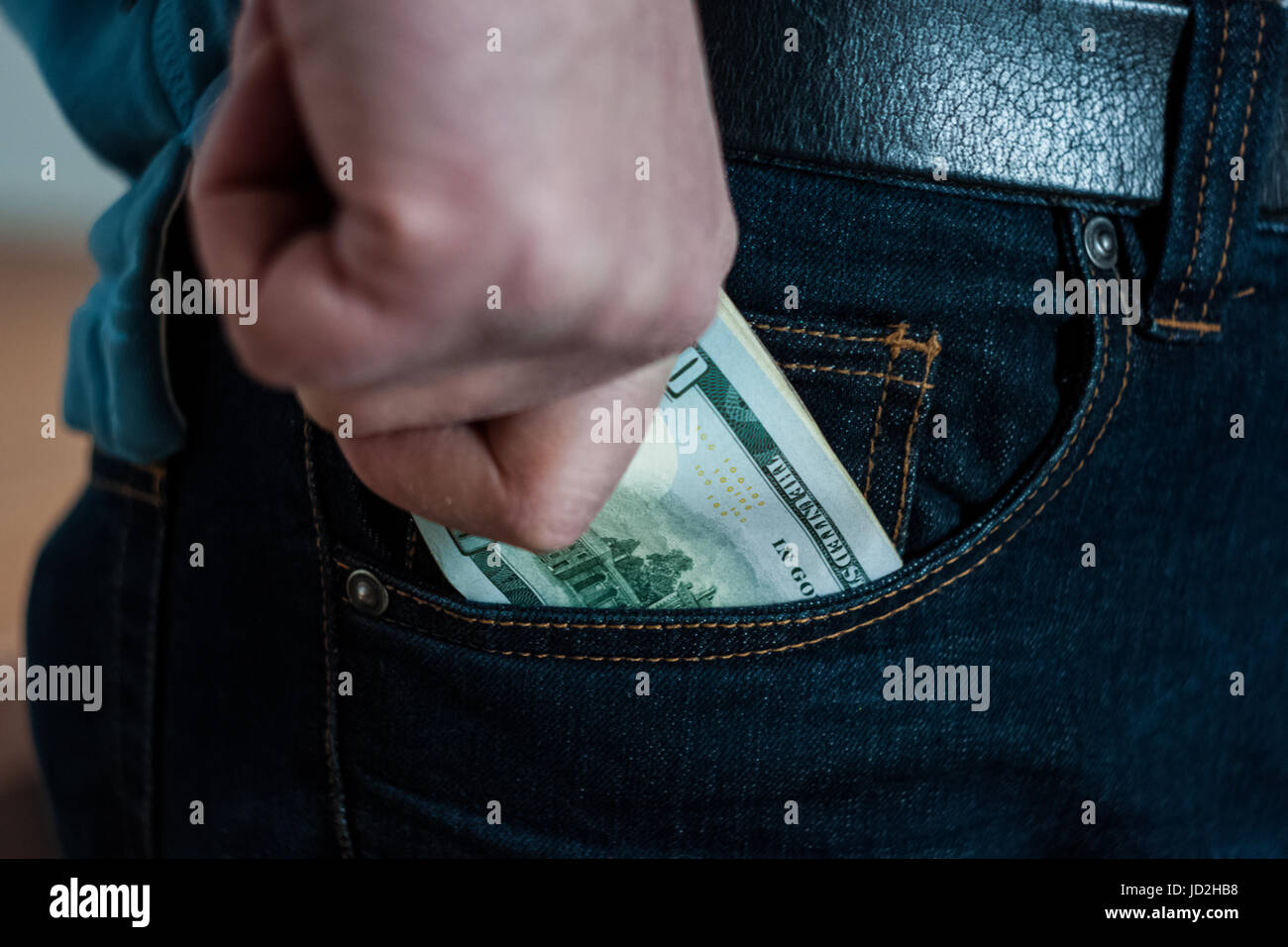 Paper money man holding tightly pinched in his hand, trying to slip into your pocket Stock Photo