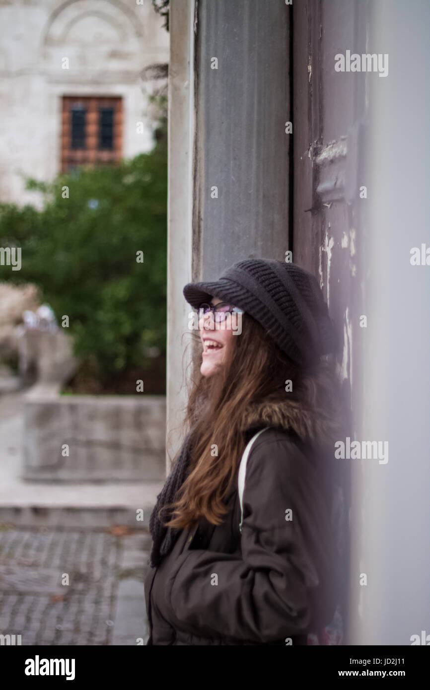 Beautiful cute little blonde girl with glasses leaning against the old ...