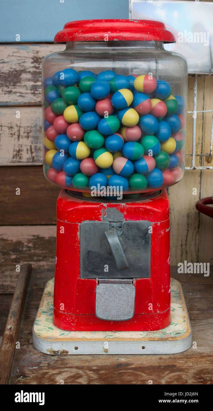 Bubble gum ball in rusty vending machine in retro style. Stock Photo