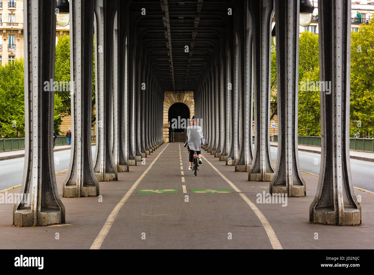 Metal columns and abutments of '' Bir Hakeim '' bridge. People walks and make jogging under the bridge in Paris.The bridge is one of the most famous a Stock Photo
