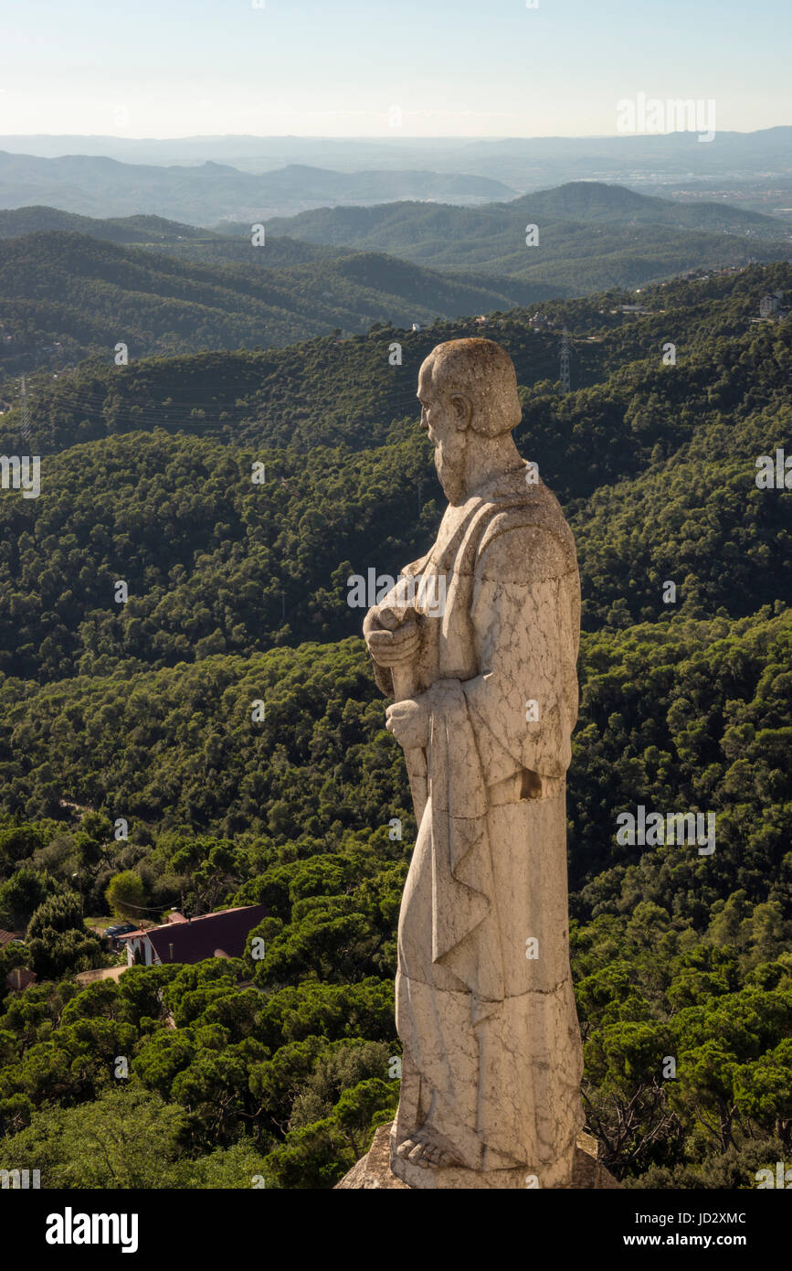 Statue of saint at the Expiatory Church of the Sacred Heart of Jesus overlooking the Sierra de Collserola hills surrounding the Tibidabo Mountain in B Stock Photo