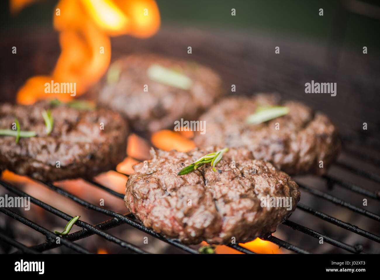 BBq meat burgers over charcoal flames Stock Photo Alamy